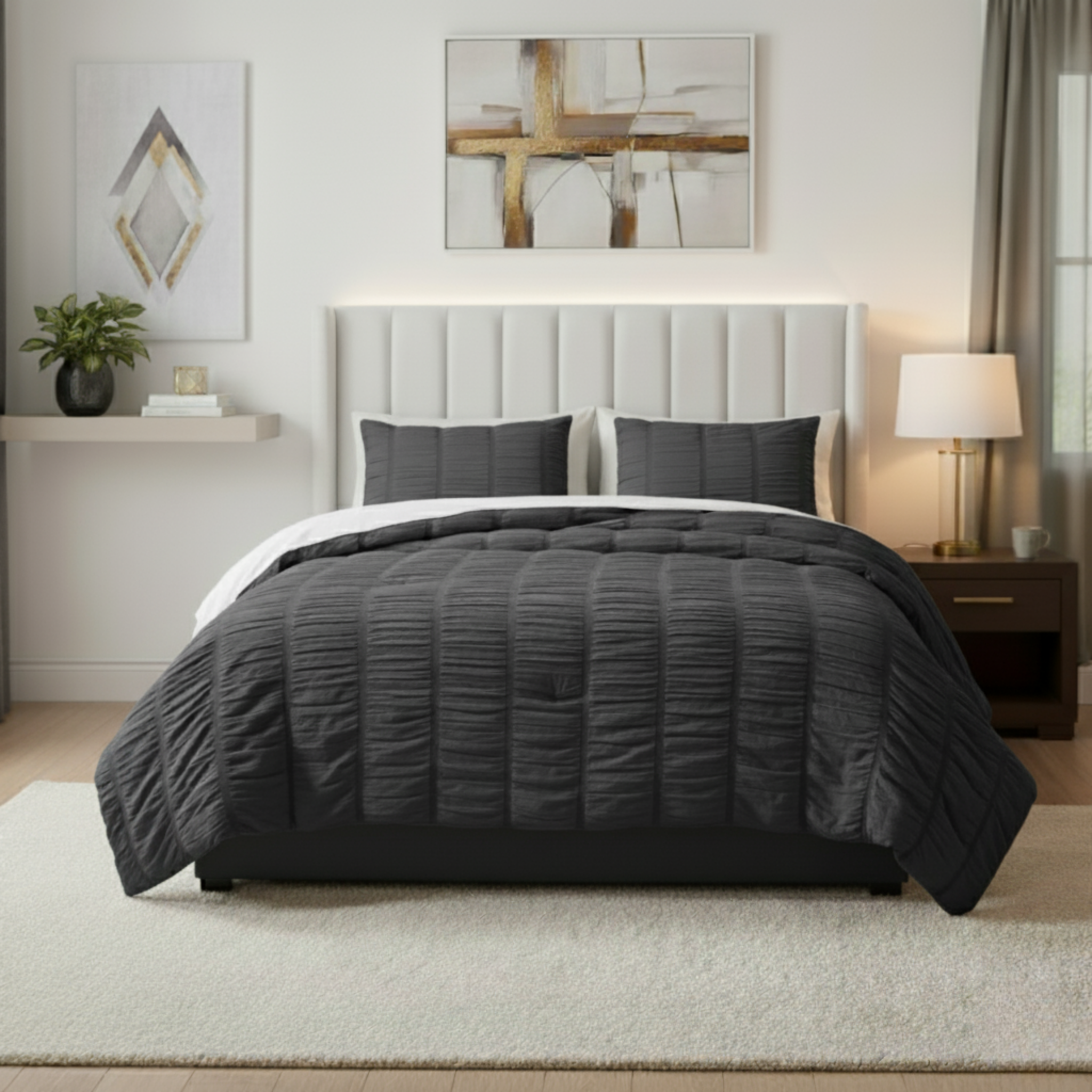 Gray comforter set on a bed in a modern bedroom with abstract art and a lamp.